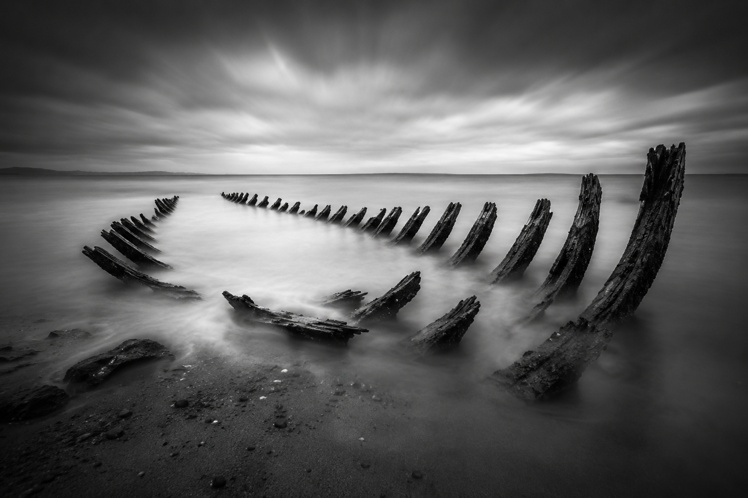 Shipwreck silhouette against stormy sky